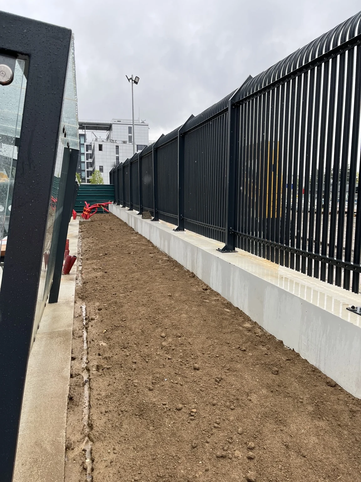 Linéaire de clôture barreaudée en cours de pose