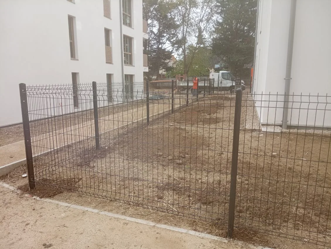 Détail de clôture grillagée fixée sur poteaux