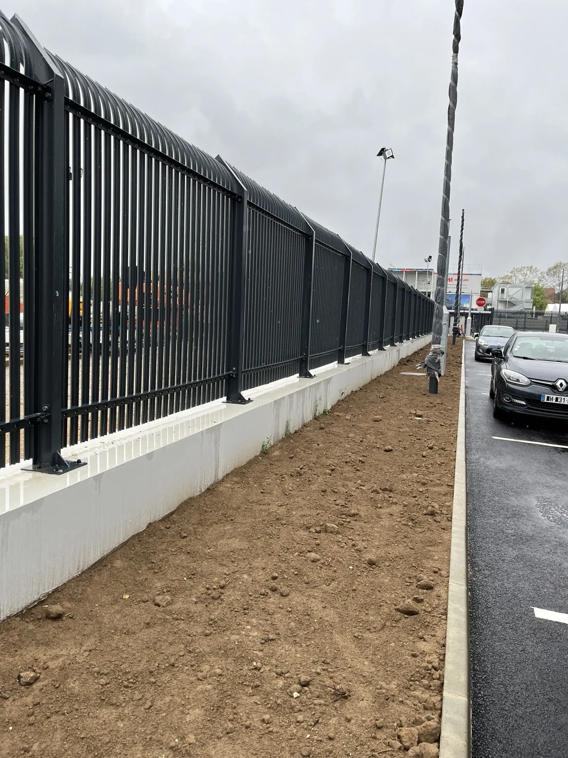 Panneaux de clôture fixés sur un soubassement béton