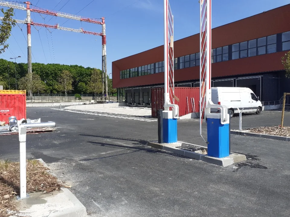 Barrière levante avec portique de limitation de hauteur sur un accès poids lourds