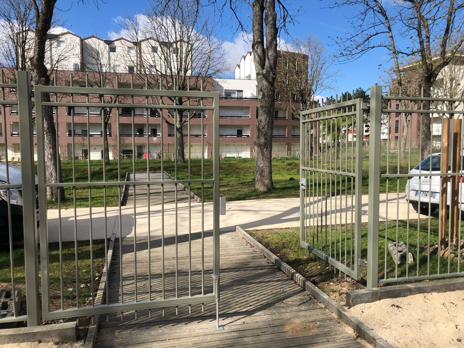 Portail pivotant en acier dans un accès urbain