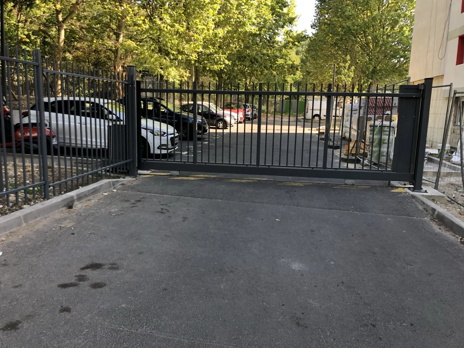 Portail coulissant fermant une entrée bordée d’arbres